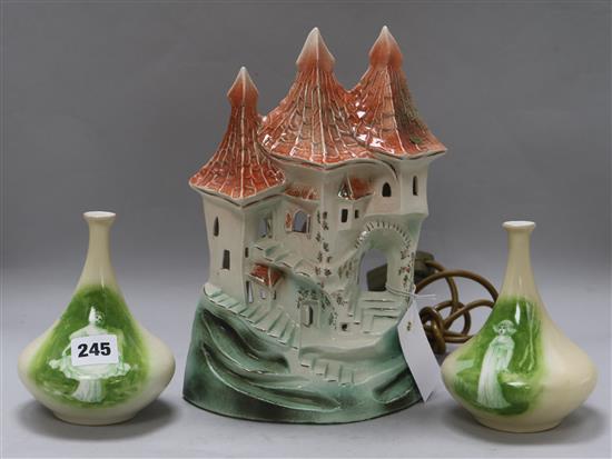 A castle-shaped pottery lamp and a pair of vases